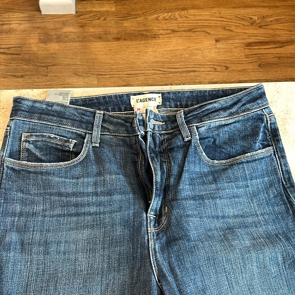 L’Agence Women’s Jeans. Size 28. Distressed knee and hem. Straight, dark wash.